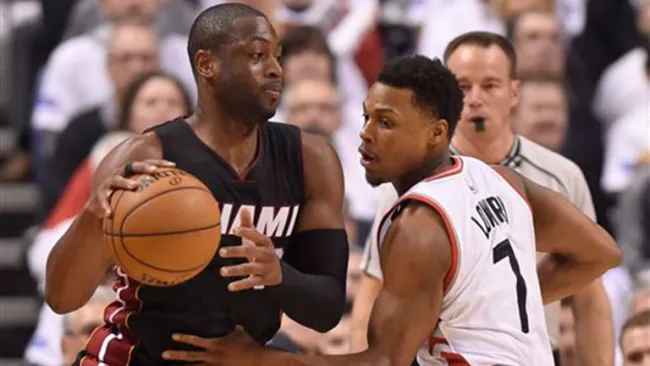 Dwyane Wade controla el balón frente a Kyle Lowry, de los Raptors