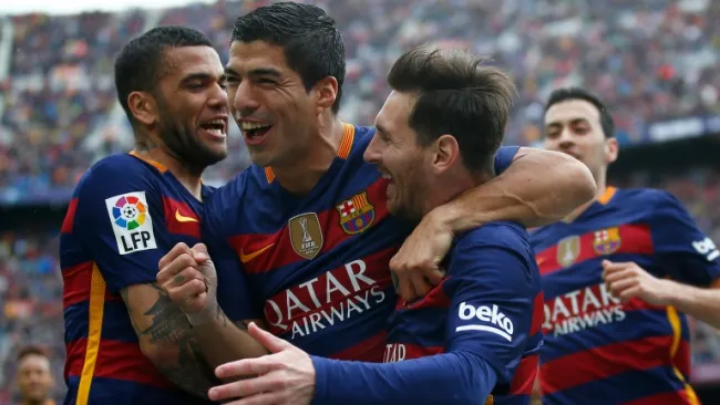 Suárez festejando una anotación con Messi y Alves