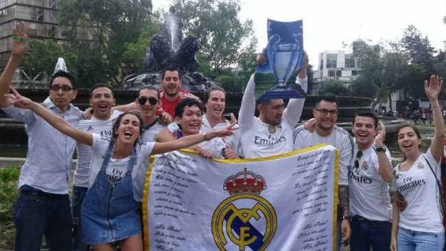 Aficionados merengues celebrando en la Fuente de la Cibeles