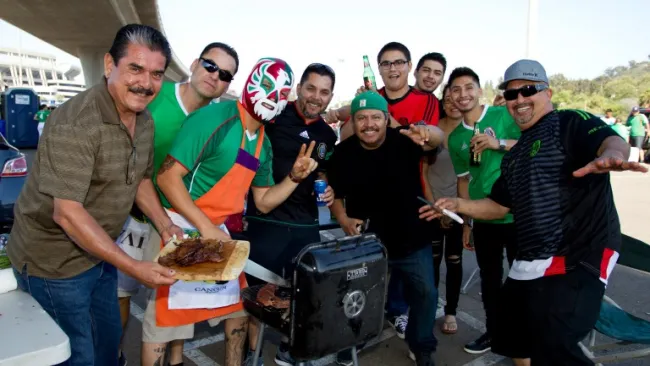Aficionados mexicanos afuera del estadio haciendo un asado