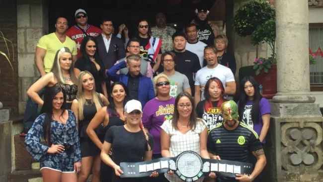 Luchadores extranjeros posan con el cetro de campeón