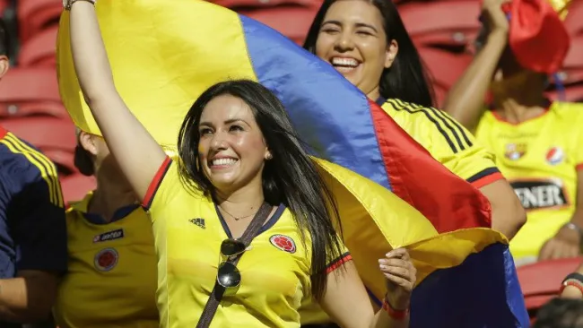 Una bella aficionada posa con la bandera de Colombia