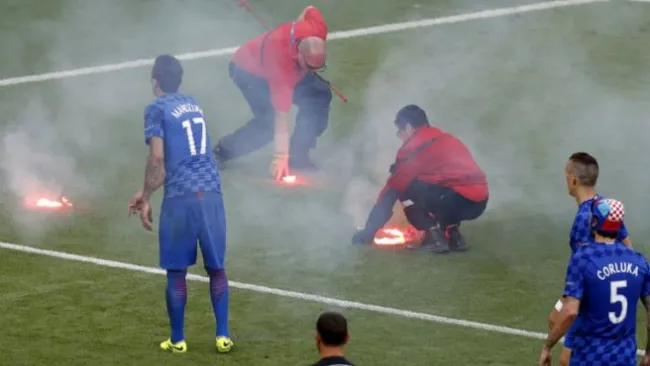 Personal del Staff de la Euro recoge bengalas arrojadas por aficionados