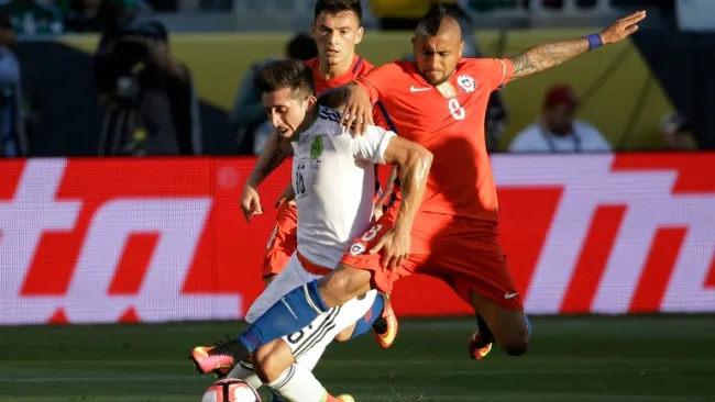 Héctor Herrera y Arturo Vidal pelean un balón