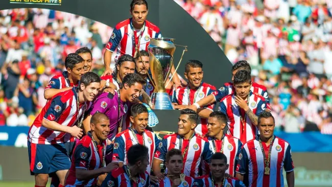 Jugadores de Chivas posan con el trofeo de la Supercopa MX