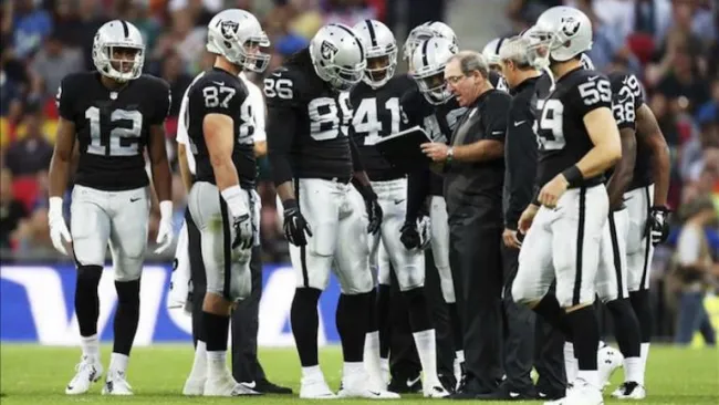 Jugadores de Raiders dialogan durante un encuentro de la NFL