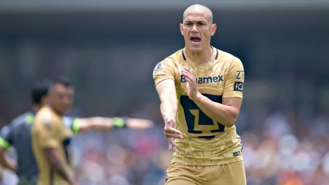 Darío Verón señala una mano en un partido de Pumas