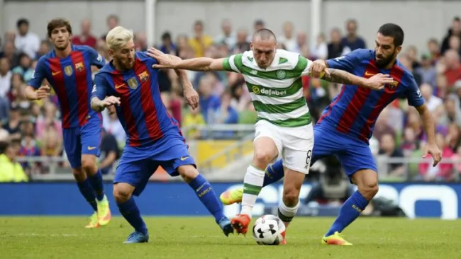 Scott Brown pelea un balón con Messi y Turan en el duelo entre Celtic y Barça 