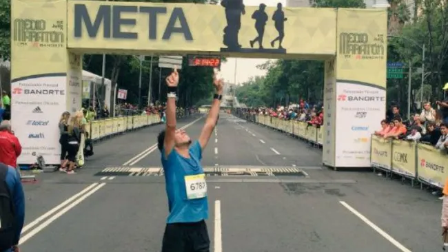 Corredor festeja tras cruzar la meta del Medio Maratón de la CDMX