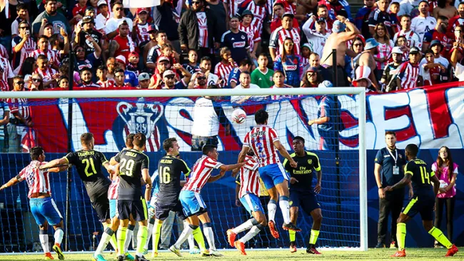 Intensa pelea por el balón en el área entre Chivas y Arsenal