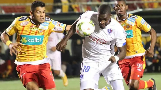 Luis Omar Hernández (amarillo y rojo) disputa un balón en juego de Herediano