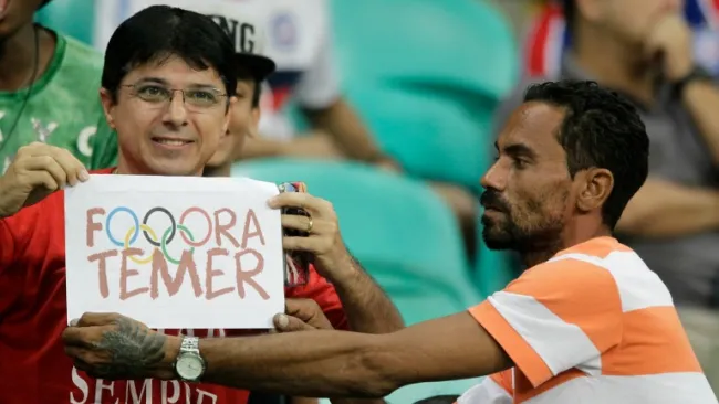 Un aficionado muestra un cartel donde se lee 'Fuera Temer'