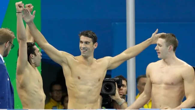 Michael Phelps (centro) festeja con sus compañeros el triunfo 