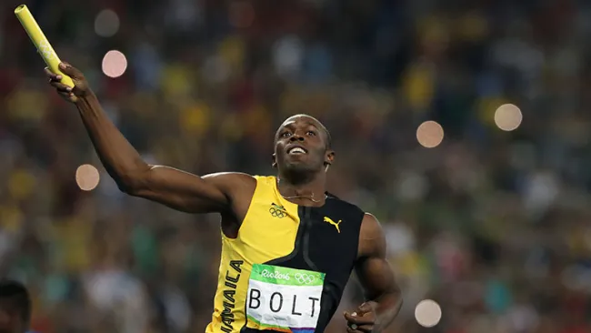 Usain Bolt levanta la estafeta en señal de victoria 