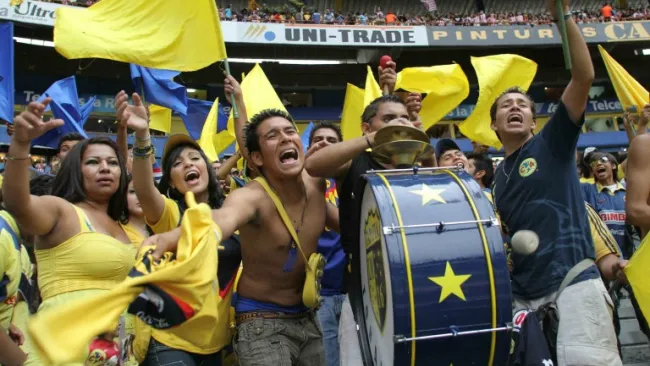 Aficionados del América apoyan a su equipo en un partido