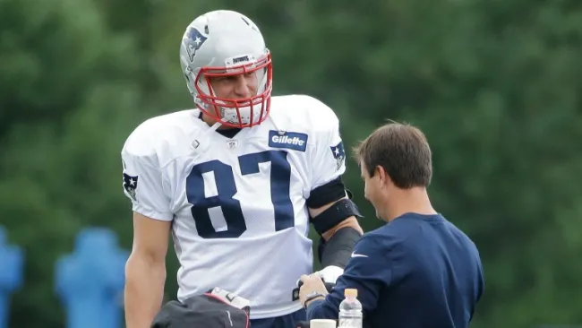 Rob Gronkowski platica con uno de los coaches en un entrenamiento
