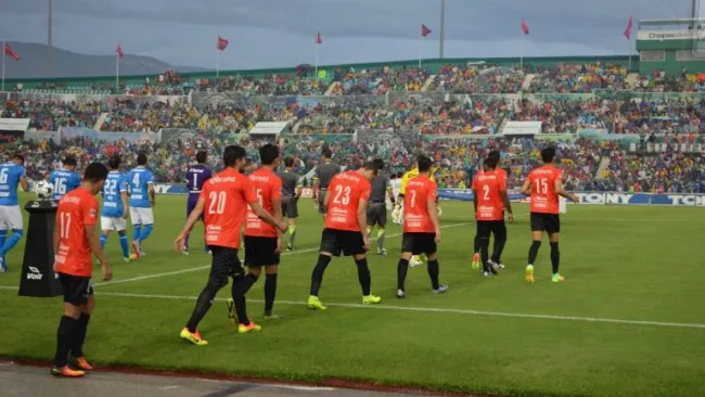 Jugadores de Chiapas saltan al terreno de juego con la playera color naranja