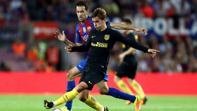 Antoine Griezmann conduce balón ante la presión de Busquets