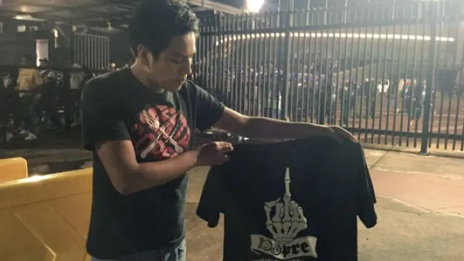 Aficionado de Pumas muestra la playera negra afuera del Olímpico