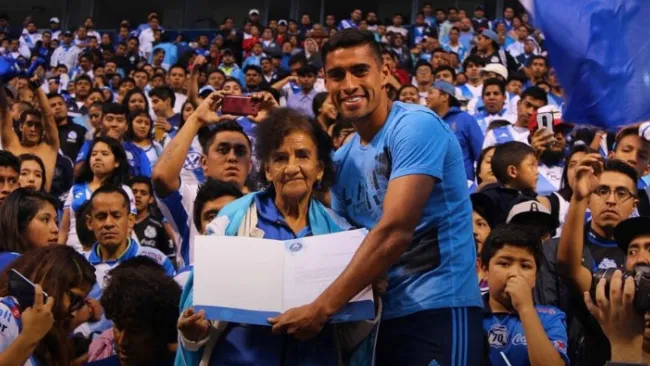 Patricio Araujo entrgándole un agradecimiento a Doña Male en el estadio Cuauhtémoc