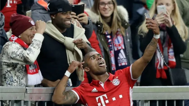 Douglas Costa se toma una selfie con aficionados después de anotar con el Bayern