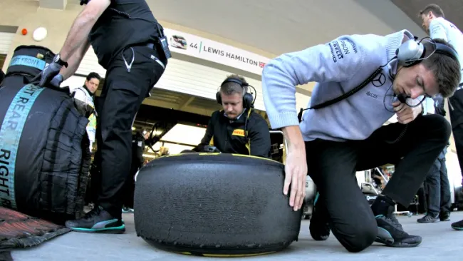 Miembros del equipo Mercedes revisan los neumáticos de Hamilton