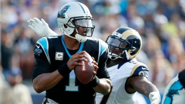 Cam Newton con el balón durante el juego contra Rams