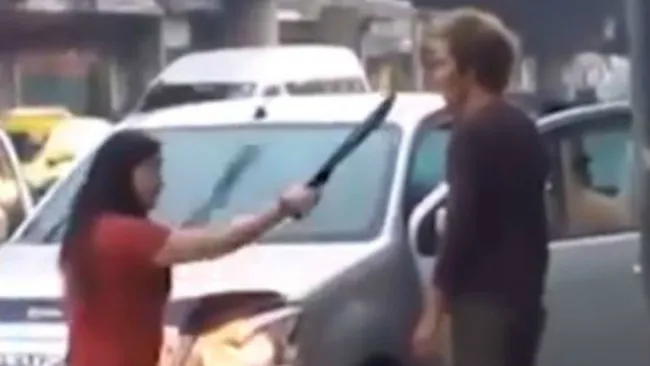 Mujer amenaza con machete a su esposo