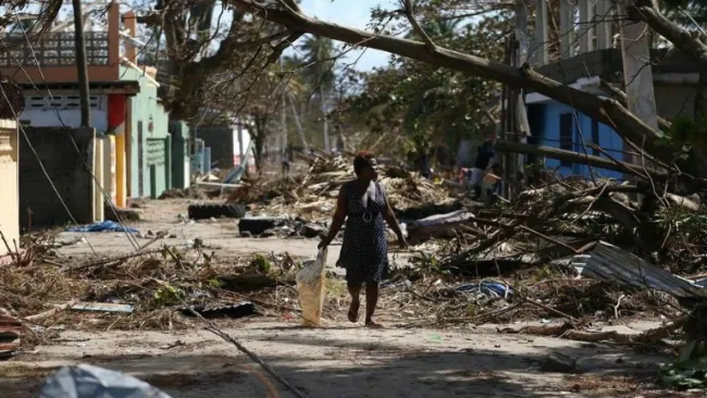 Una mujer camina por una zona de desastre tras el paso de Matthew