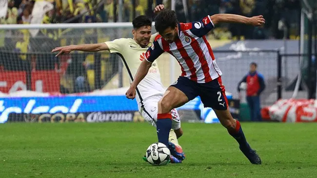 Peralta y Alanís pelean por el balón en el pasado Clásico