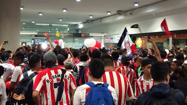 Decenas de aficionados de Chivas esperan la llegada de su equipo en aeropuerto