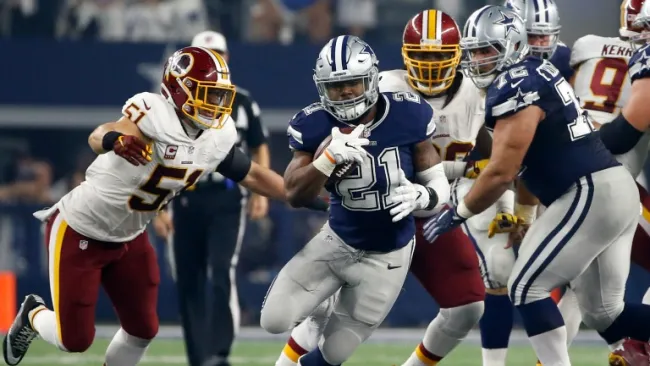 Elliott acarrea el ovoide entre los defensivos de Washington
