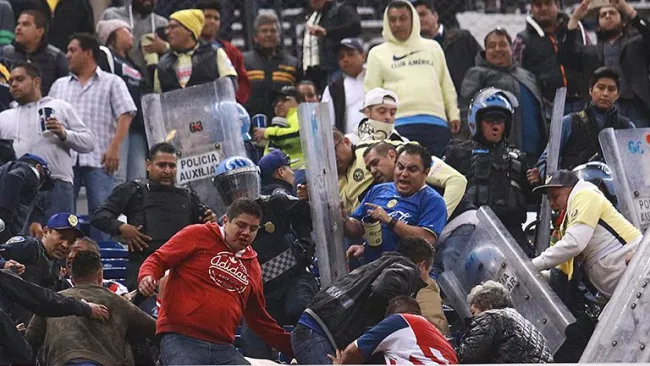 Aficionados se enfrentan con policías en el Azteca