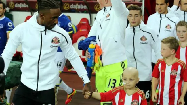 El pequeño Bradley sale agarrado de la mano de Jermaine Defoe