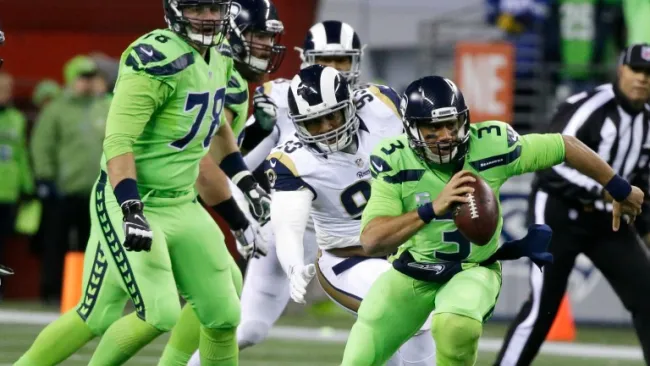 Russell Wilson corre con el balón durante el juego contra Rams