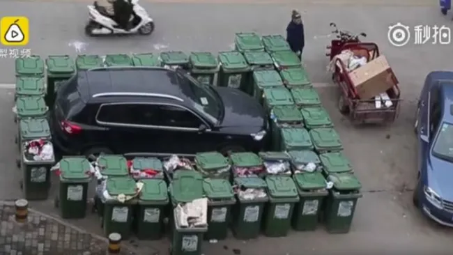 La camioneta rodeada por contenedores de basura