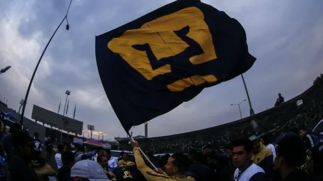 Aficionado de Pumas, con una bandera de su equipo
