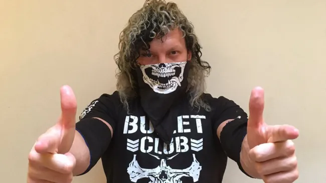 Kenny Omega posa con una camiseta del Bullet Club