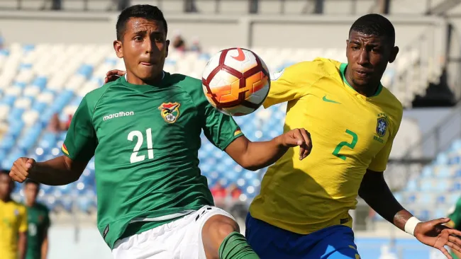 Emerson de Brasil lucha por la pelota contra Roberto Fernandez 