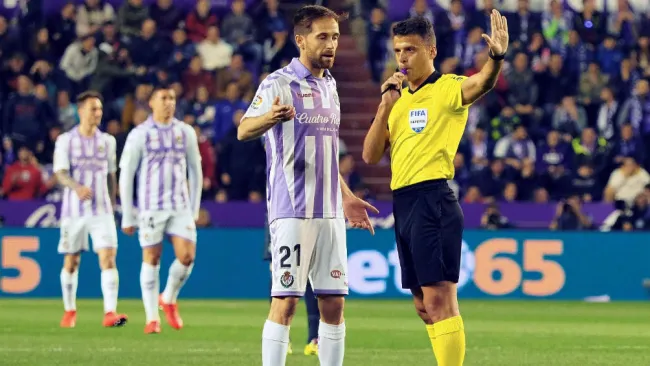 El árbitro anuncia que se revisa una jugada durante el partido