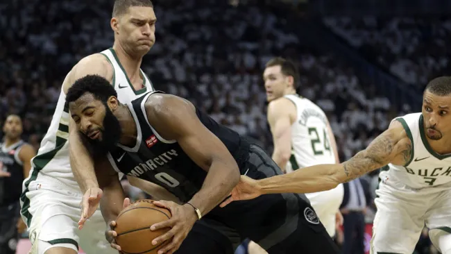 Andre Drummond recibe una falta cuando conduce entre Brook Lopez y George Hill 