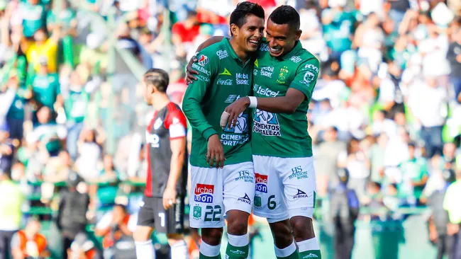 Jugadores de León se abrazan en el juego contra Atlas