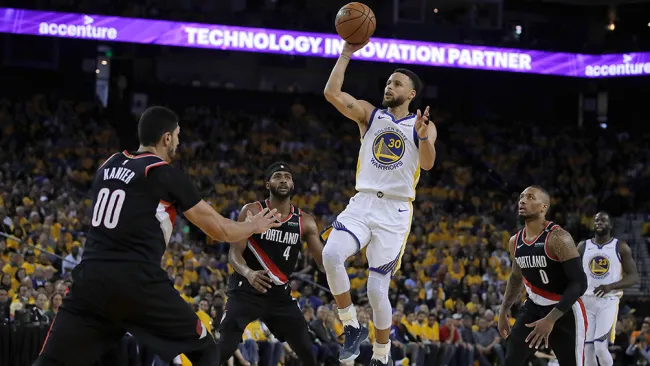 Curry lanza el balón entre defensivos de Portland