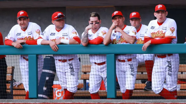Jugadores de los Diablos Rojos observan el duelo