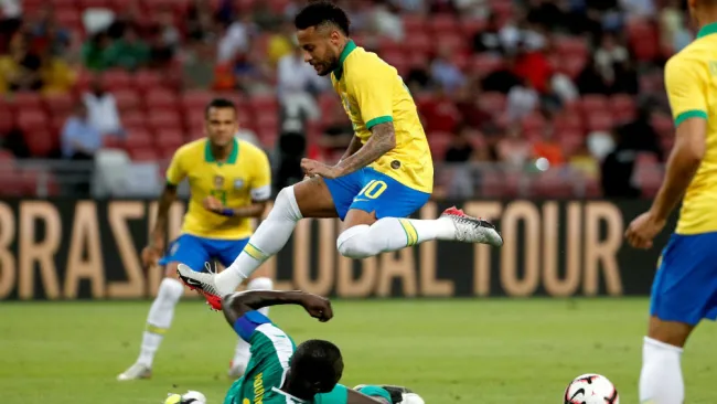 Neymar trata de evadir una barrida en el partido ante Senegal