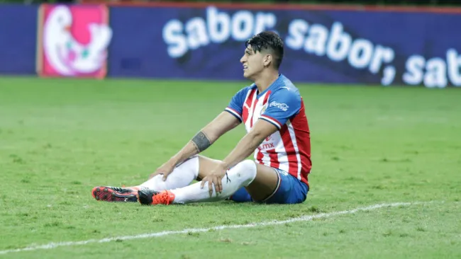 Alan Pulido en el césped durante un duelo de Chivas