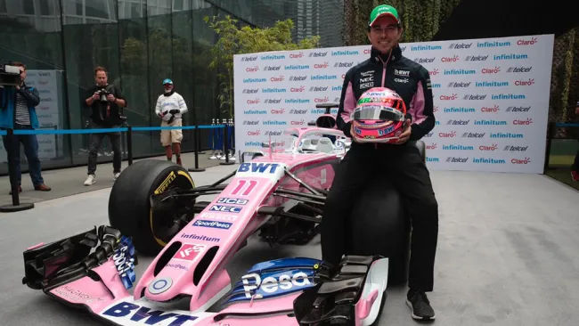 Checo Pérez posa con su casco y monoplaza