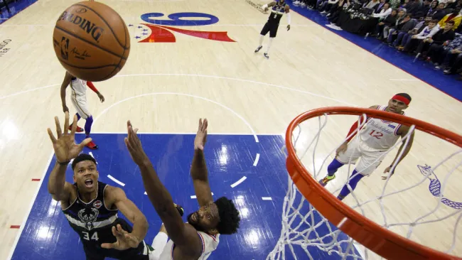 Giannis Antetokounmpo intenta anotar sobre Joel Embiid