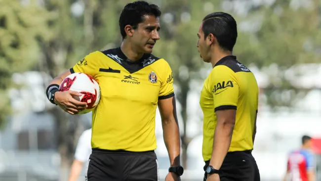 Luis Alfredo García y su asistente debaten una jugada