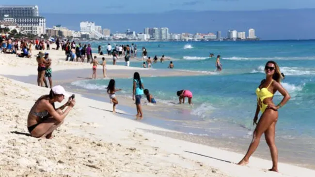 Visitantes en una playa de Cancún
